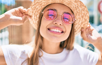 smiling girl in pink glasses-and hat