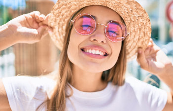 smiling girl in pink glasses-and hat
