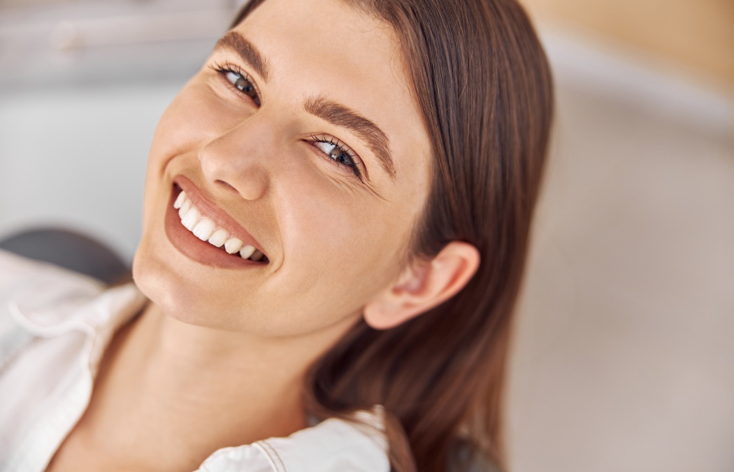 Attractive woman visiting dental clinic. Happy young woman sitting in dental chair at dentist office, Lawrenceville, GA